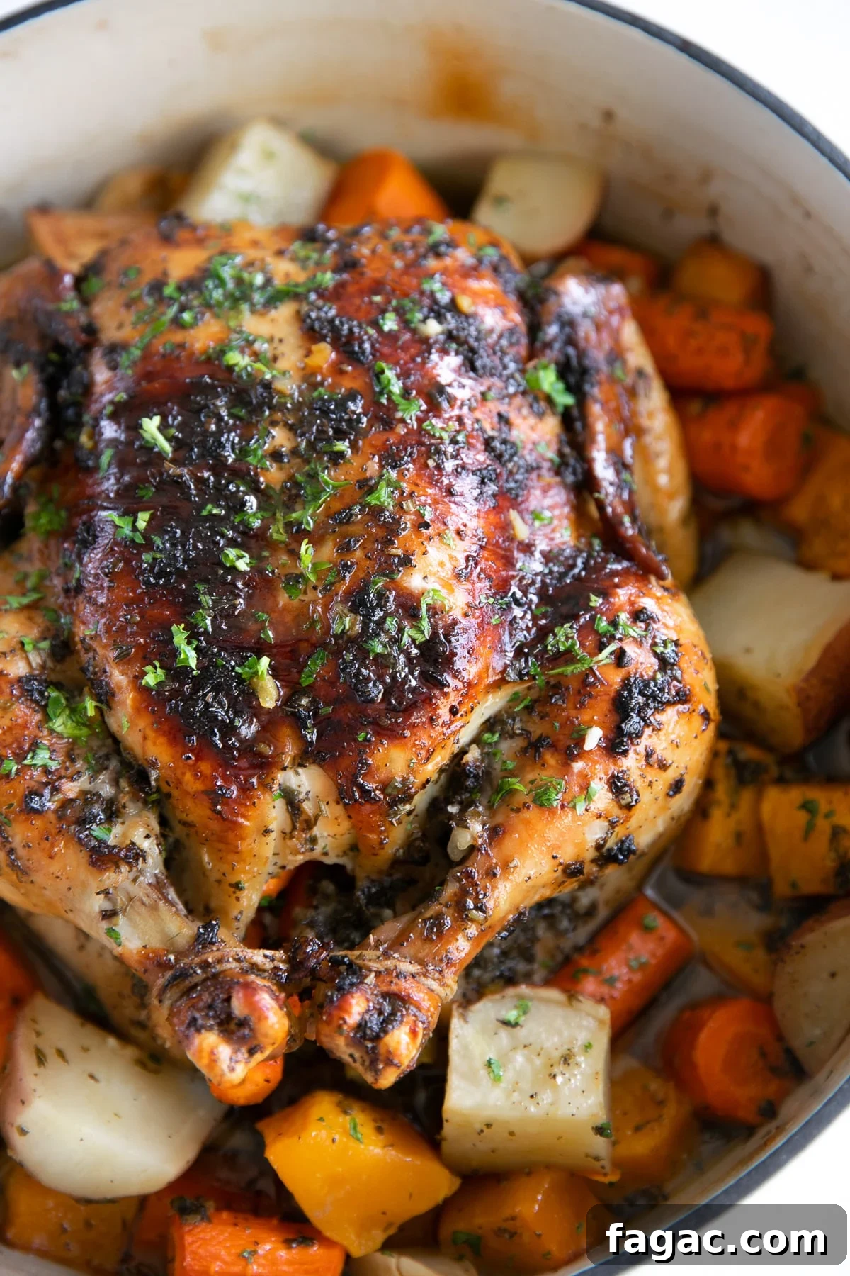 Crispy Roast Chicken with Herb Butter and Lemon 8 Perfect Roast chicken in a large round Dutch oven set atop a bed of vegetables.
