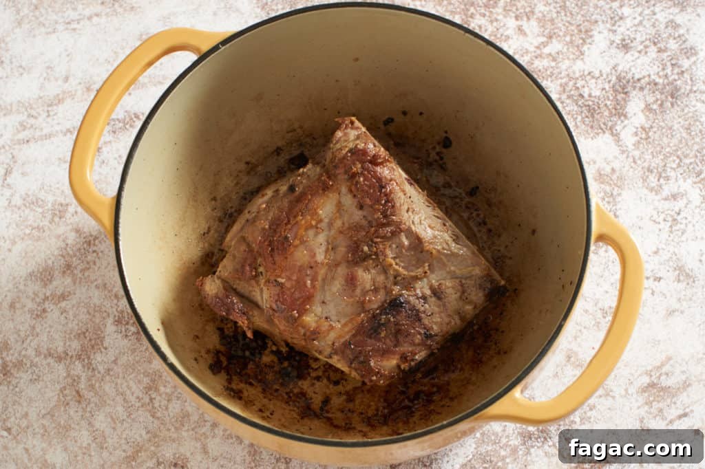 Braised Pork with White Beans, Wine & Fresh Sage 8 A yellow Dutch oven containing seared pork shoulder.