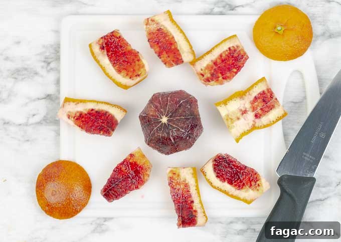 Blood Orange Salad with Tangy Orange Vinaigrette 6 Demonstrating how to slice a blood orange on white cutting board