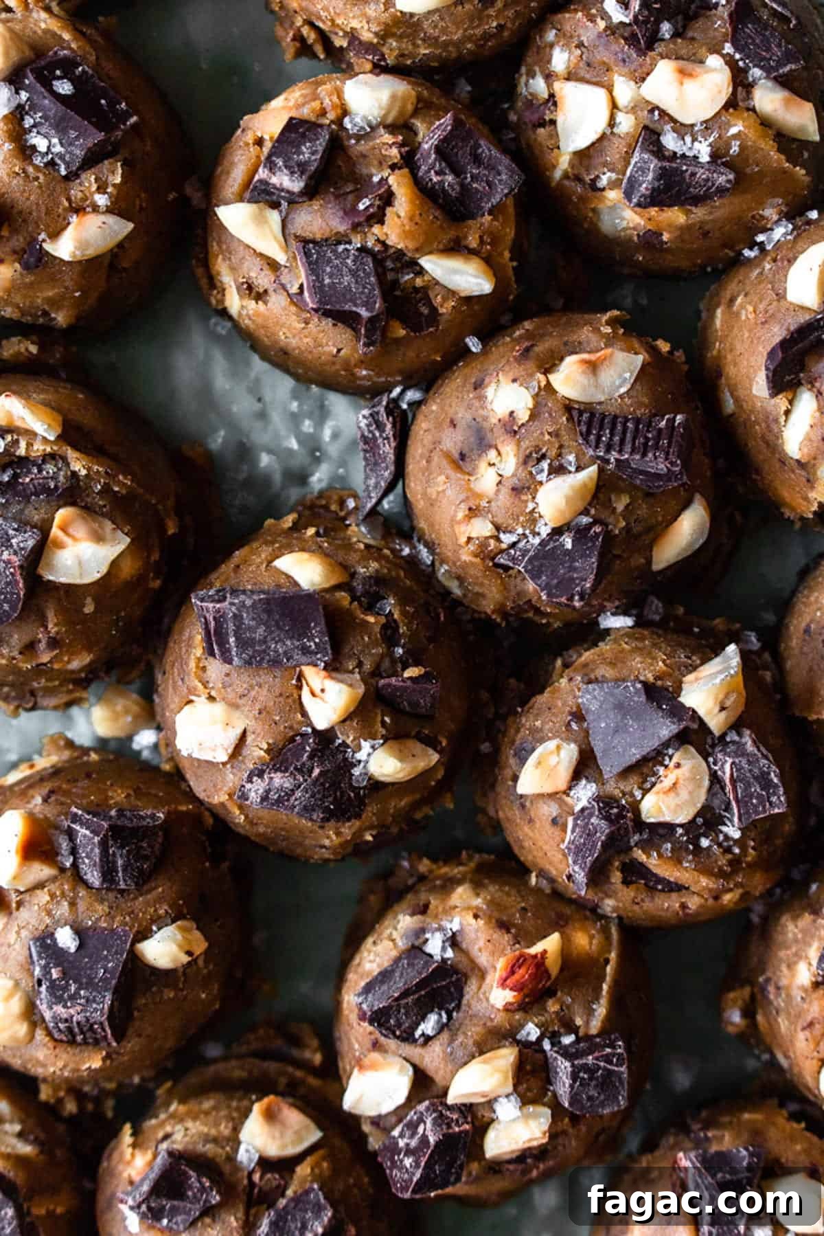 Brown butter cookie dough balls topped with chopped chocolate and hazelnuts.