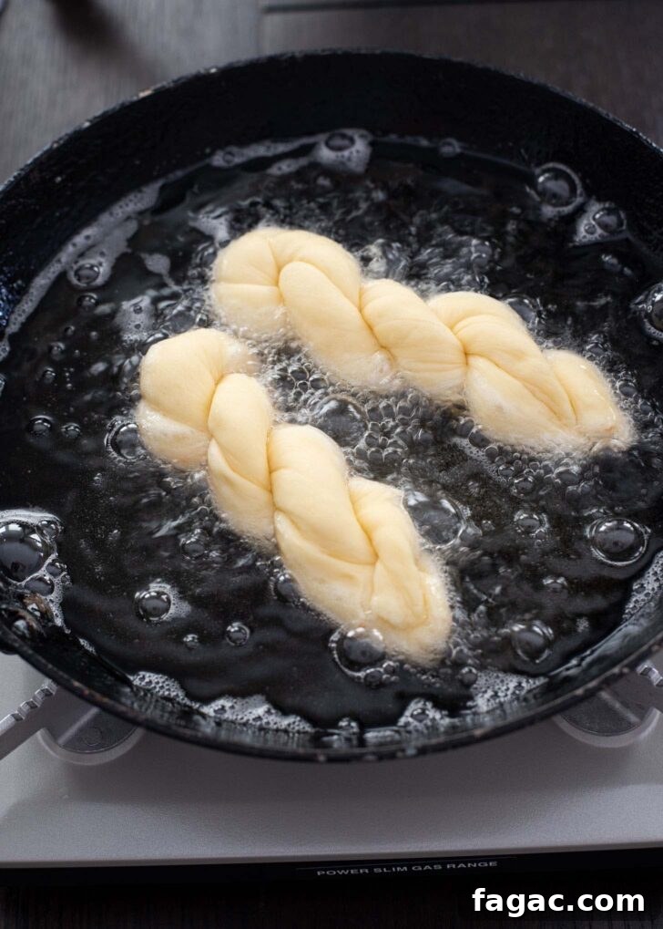 Korean Kkwabaegi Twisted Donuts Recipe: Soft Cinnamon Treats 9 Twisted kkwabaegi dough frying in hot oil until golden and puffed