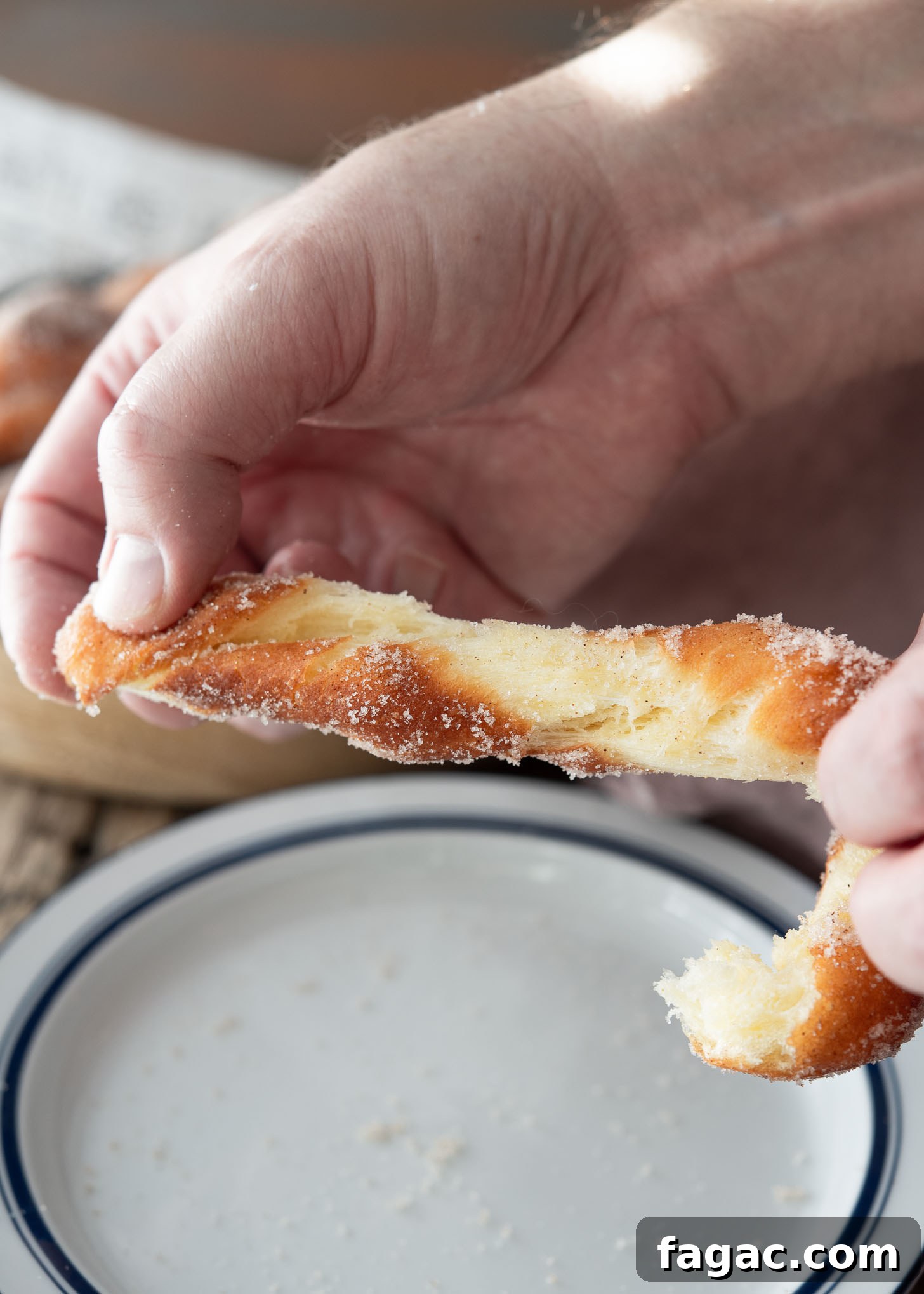 Korean Kkwabaegi Twisted Donuts Recipe: Soft Cinnamon Treats 11 Korean kkwabaegi torn open by hand, revealing a crisp exterior and soft, fluffy inside