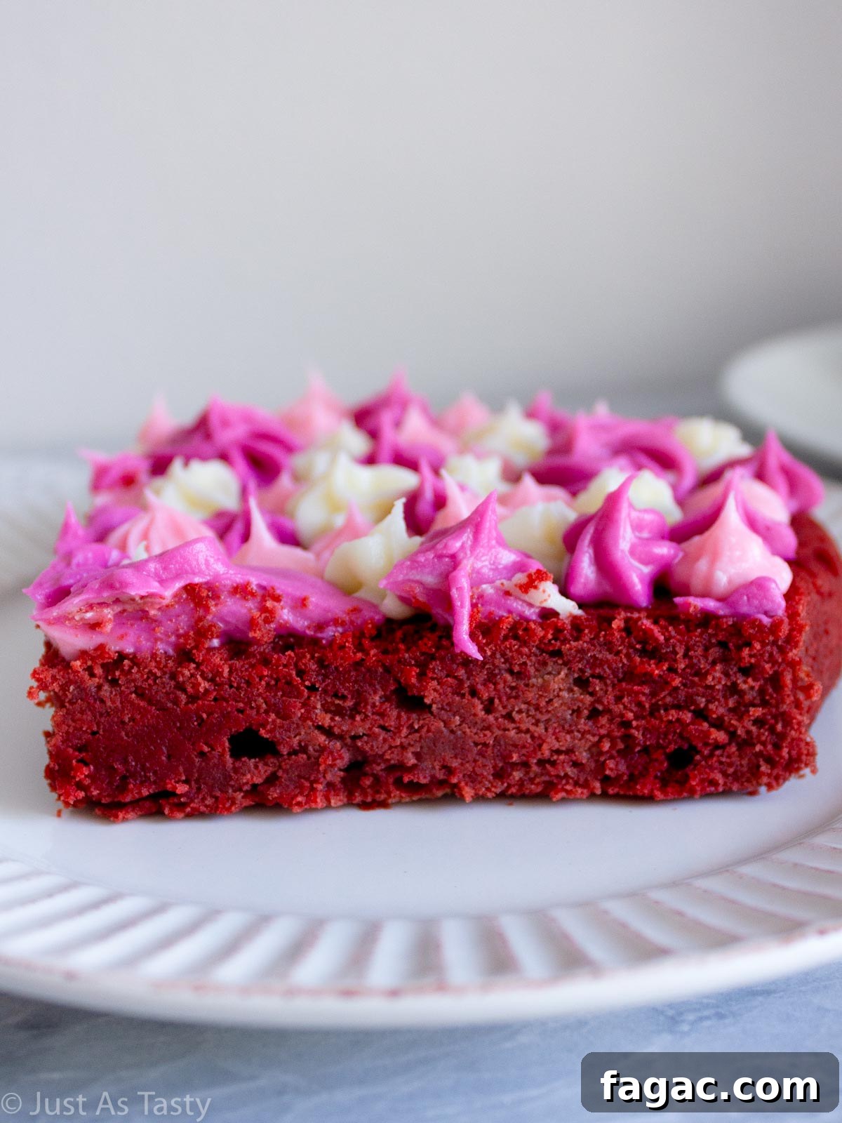 Gluten-Free Red Velvet Cake Recipe — Moist, Classic Flavor 4 Close-up of a slice of gluten free red velvet cake with piped frosting on top.