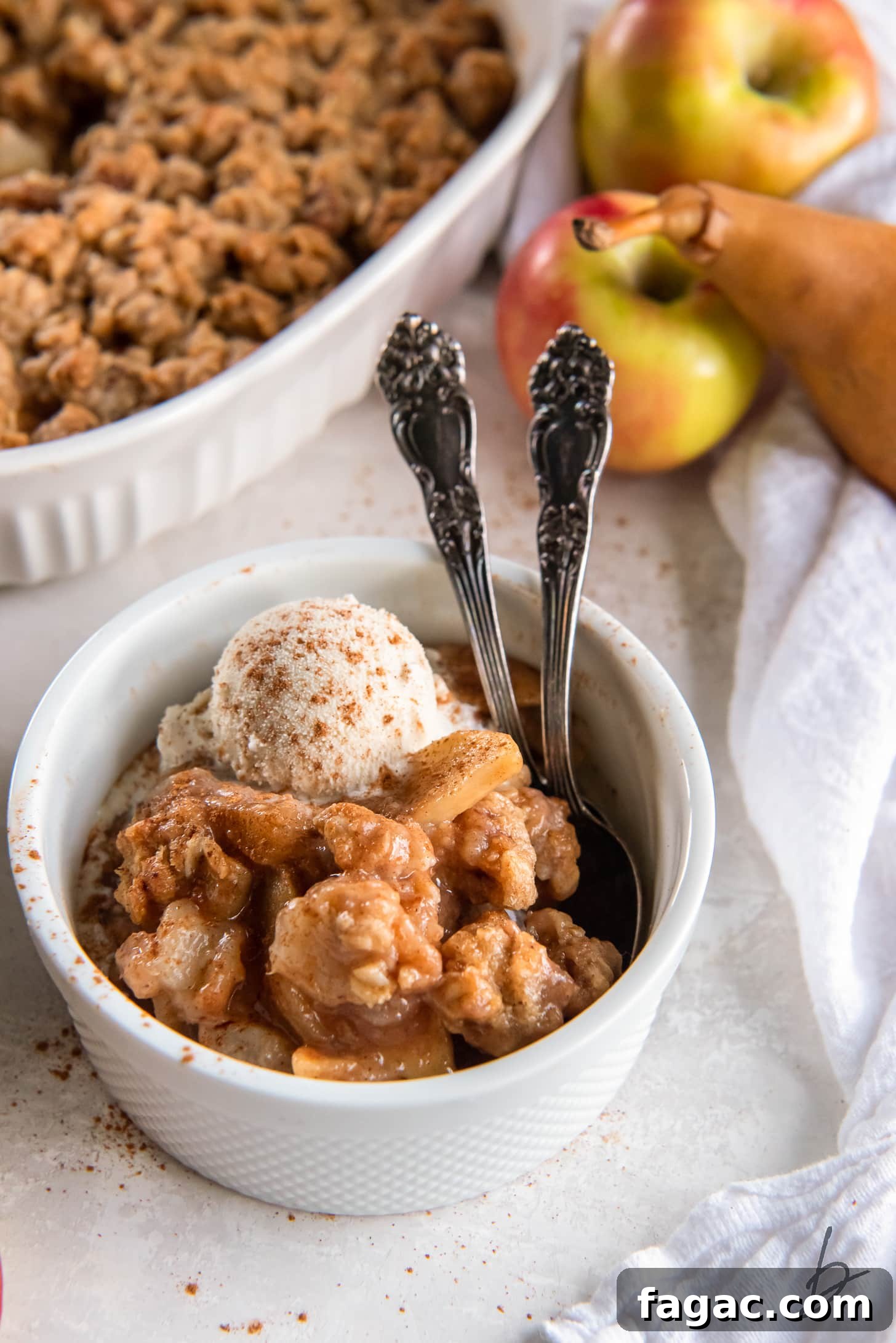 Ina Garten-Style Apple Pear Crisp Recipe 6 serving of apple pear crisp in a bowl with two spoons.