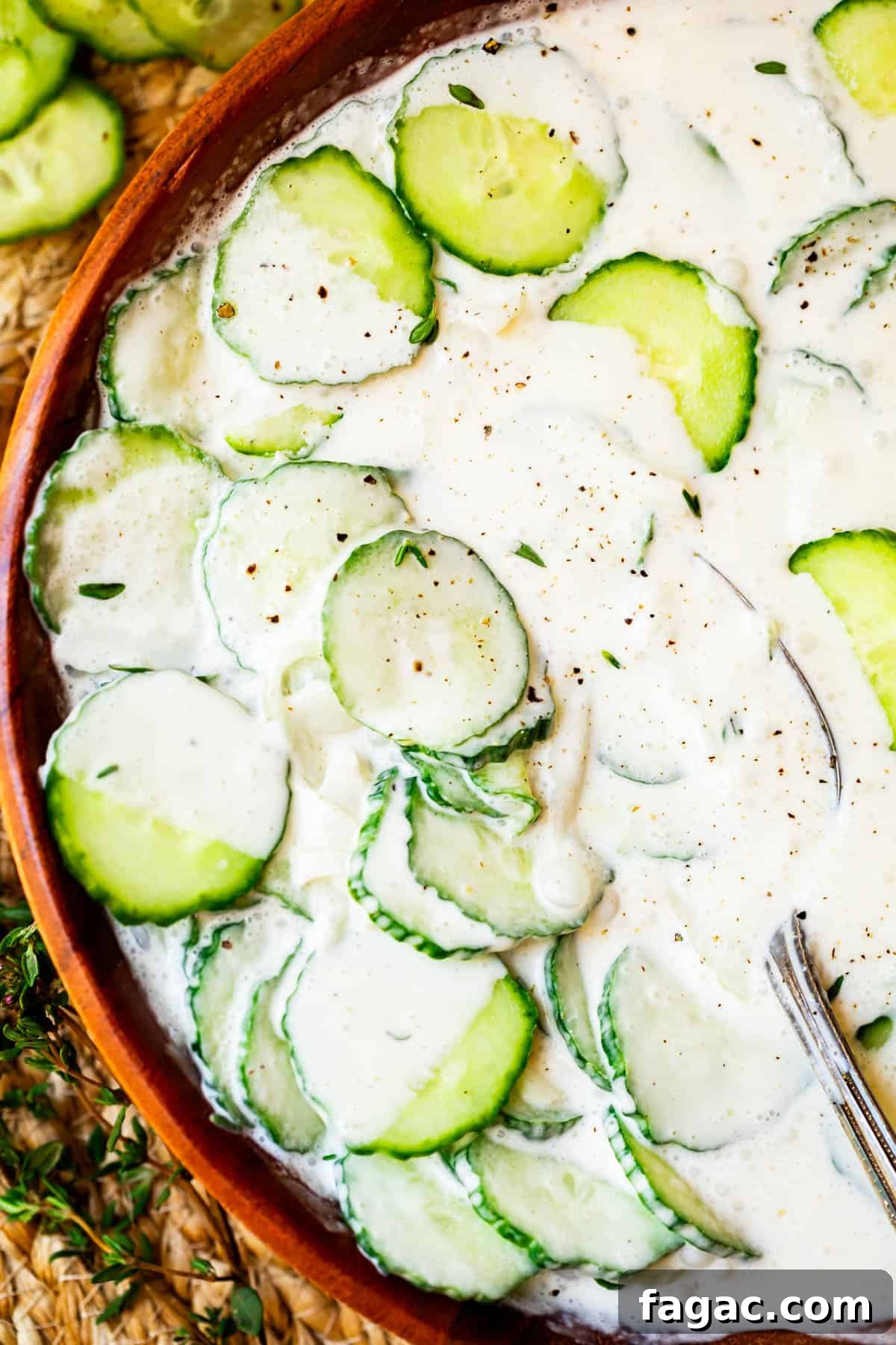 Aunt Joy’s Creamy Cucumber Salad Recipe for Summer Sides 5 creamy cucumber salad with mayo in a wooden bowl shot from overhead.
