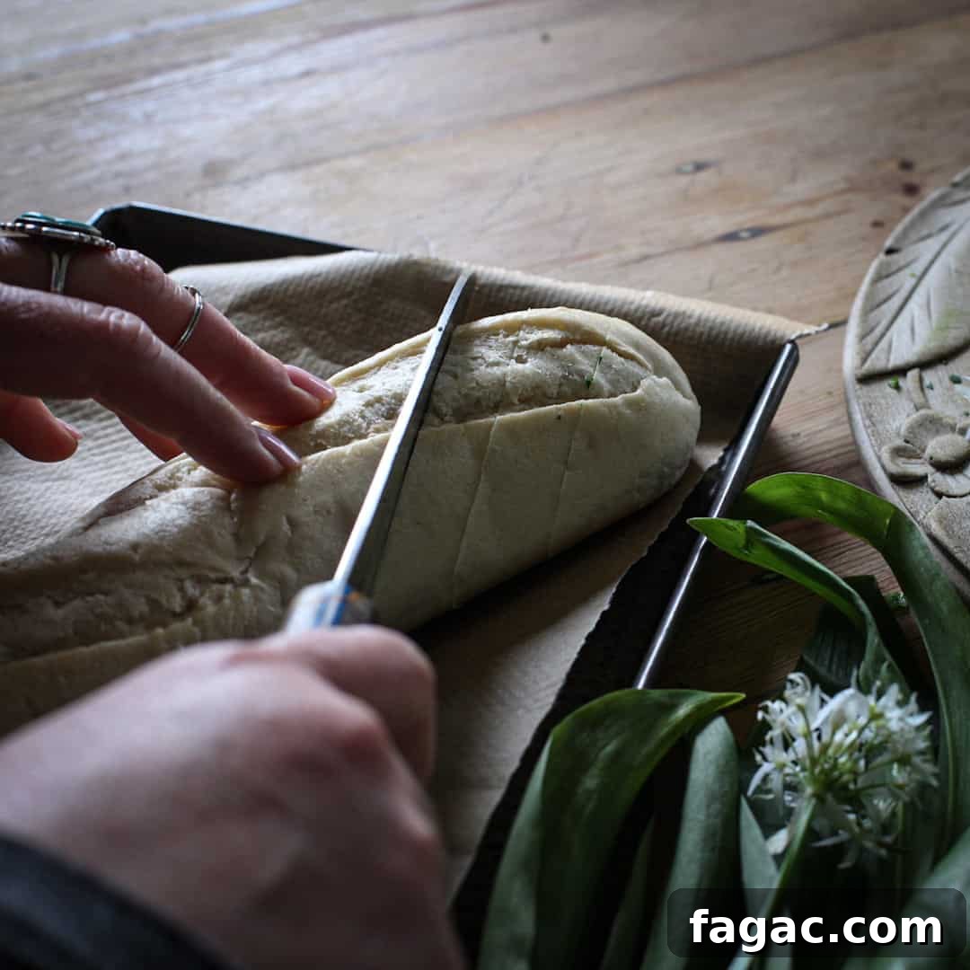 Crispy Wild Garlic Bread Recipe for Spring Gatherings 8 Woman slicing an unbaked baguette with a silver knife