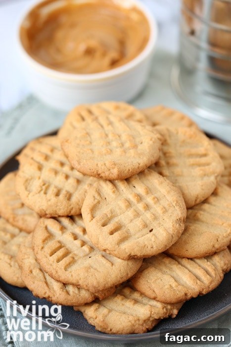 Chewy Gluten-Free Peanut Butter Cookies Recipe 11 pile of gluten free cookies with bowl of peanut butter in the background