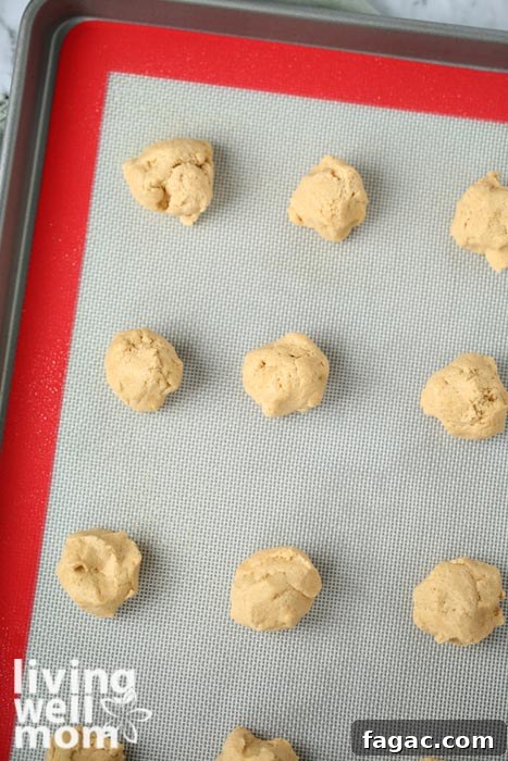 Chewy Gluten-Free Peanut Butter Cookies Recipe 8 cookie dough rounds on a baking sheet