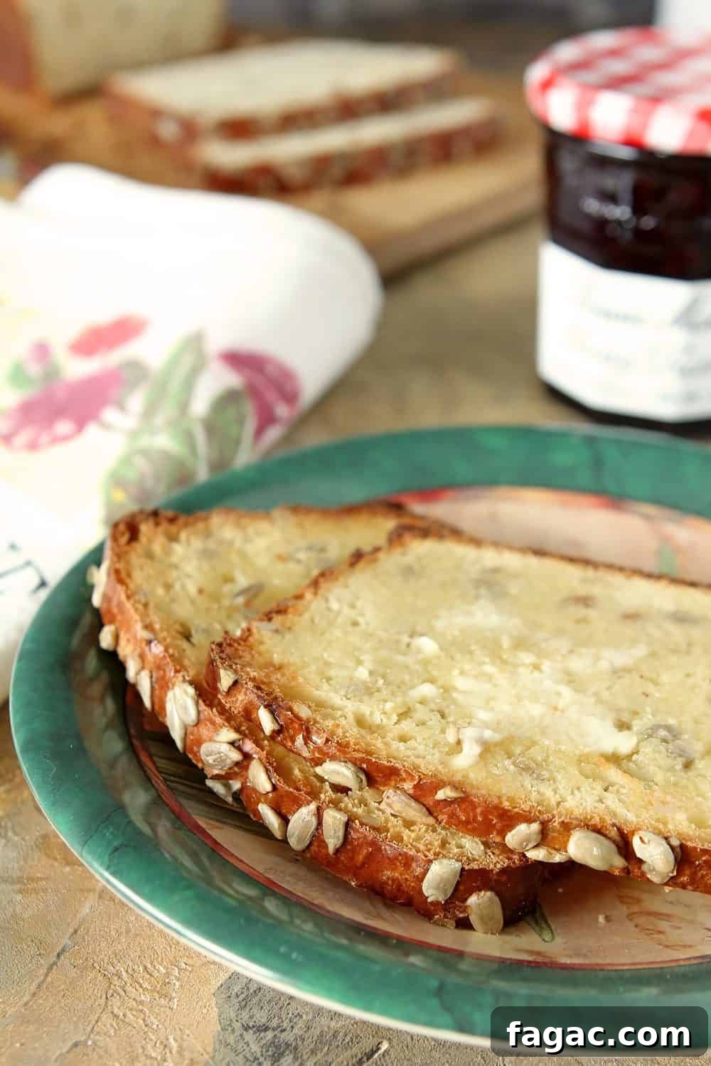 Crunchy Sunflower Seed Bread Recipe for Nutty Homemade Loaves 3 Slices of Sunflower Seed Bread are on a green edged plate and the bread is slathered with butter.