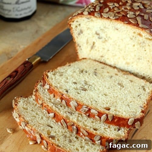 Crunchy Sunflower Seed Bread Recipe for Nutty Homemade Loaves 7 A delicious bread with both honey and sunflower seeds in the bread and scattered on top. Slices are cut open to show inside of bread loaf.