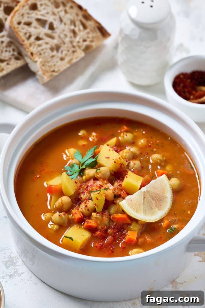 Mediterranean Chickpea Soup with Herbs and Lemon 4 A bowl filled with chopped veggies, potatoes and garbanzo bean soup.