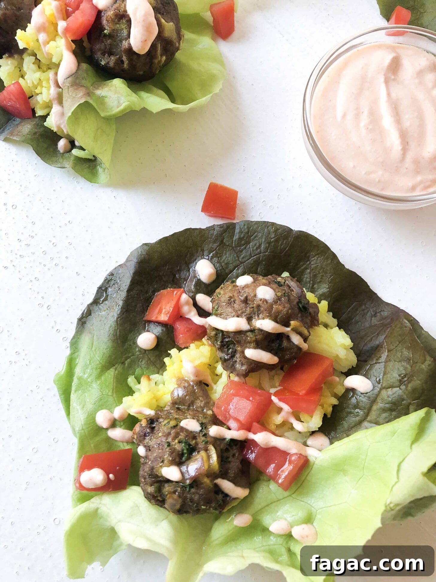 A Moroccan Kofta Lettuce Wrap with a spicy yogurt sauce