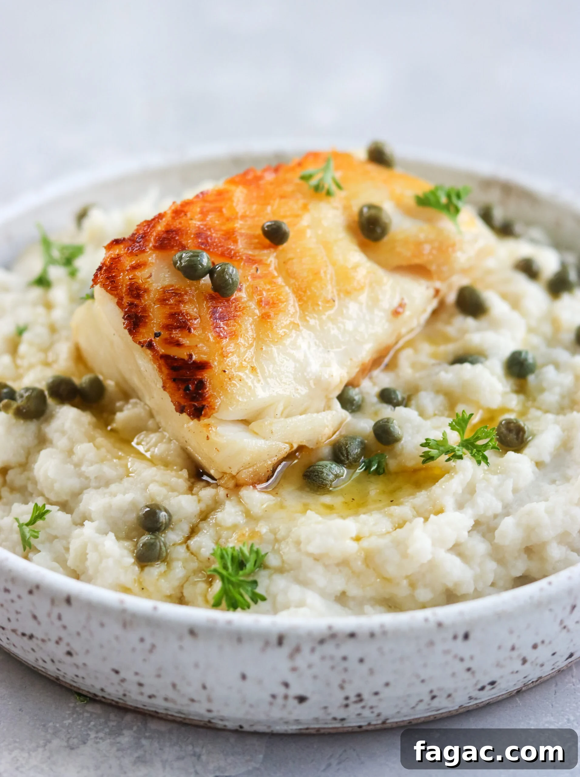 Pan Seared Chilean Sea Bass with Lemon Caper Butter on a serving dish