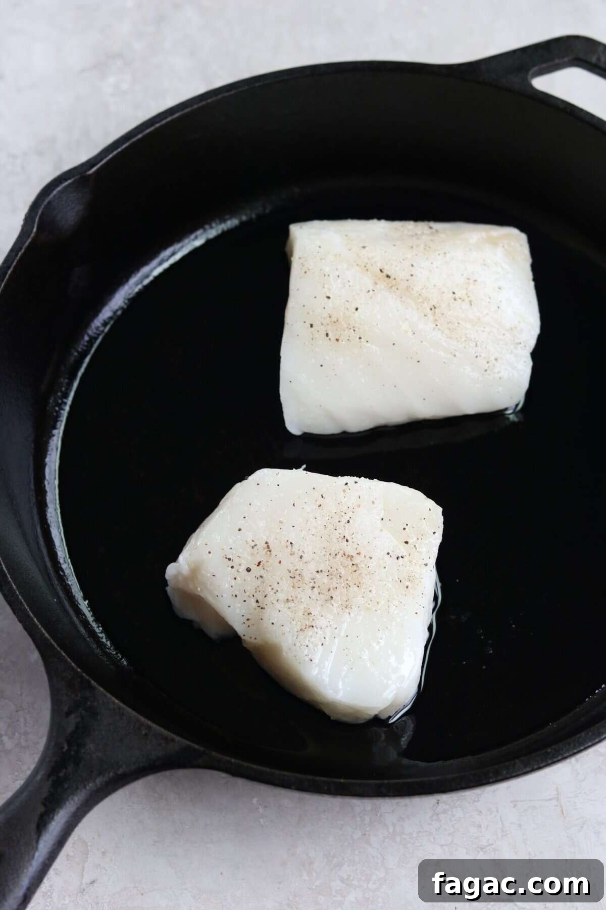 two sea bass filets in a cast iron pan