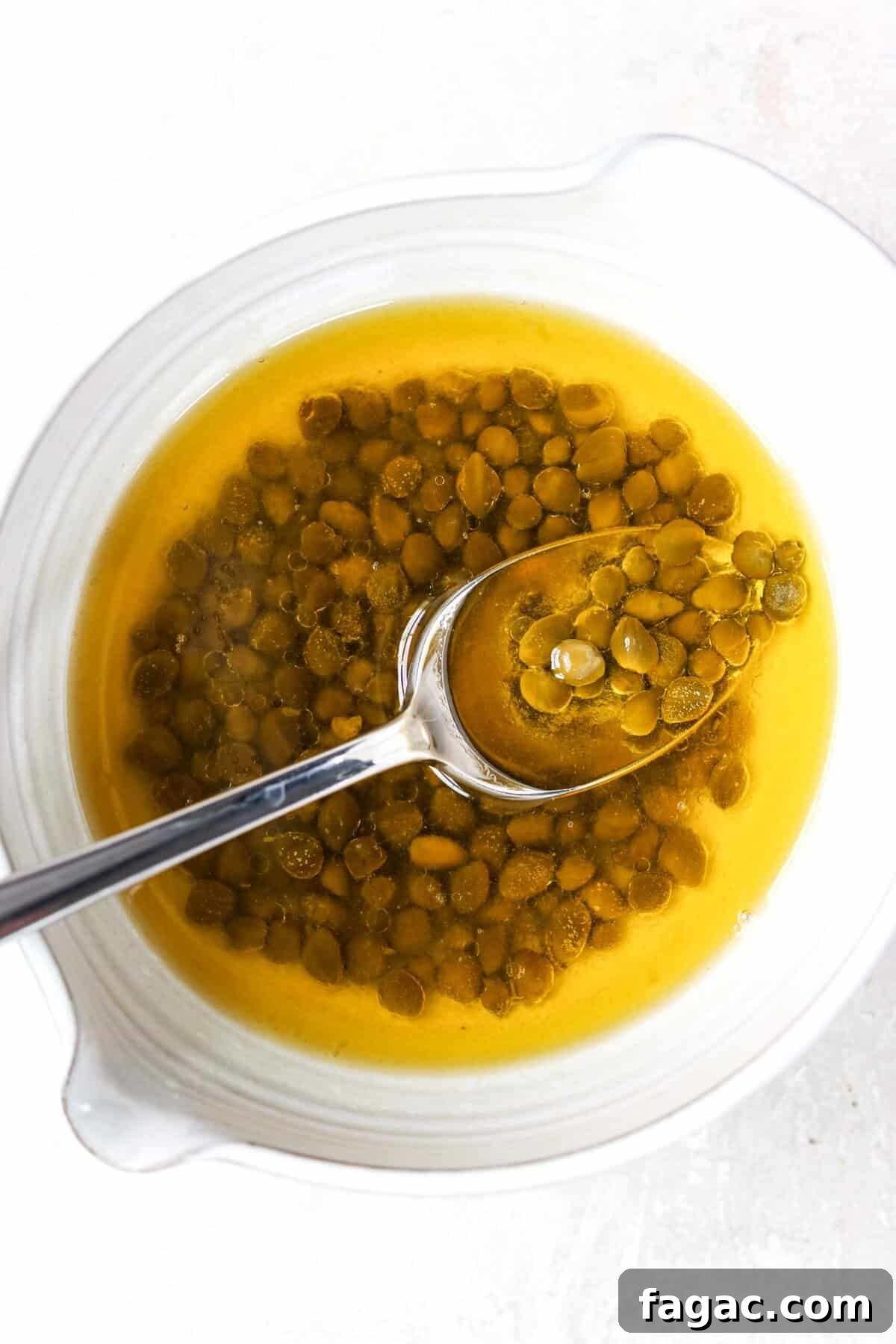 capers and melted butter in a white bowl with a spoon