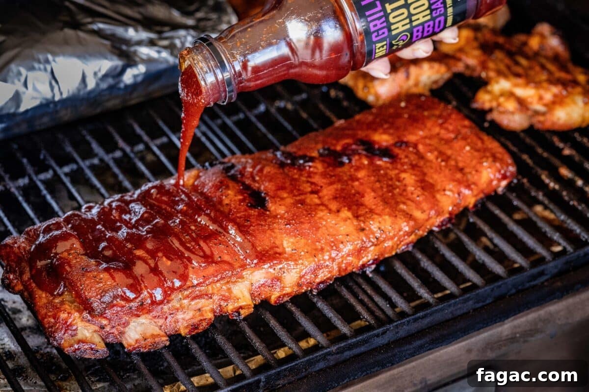Spicy Honey BBQ Sauce Recipes for Grilling and Glazing 6 A rack of ribs on the smoker being drizzled with BBQ sauce.