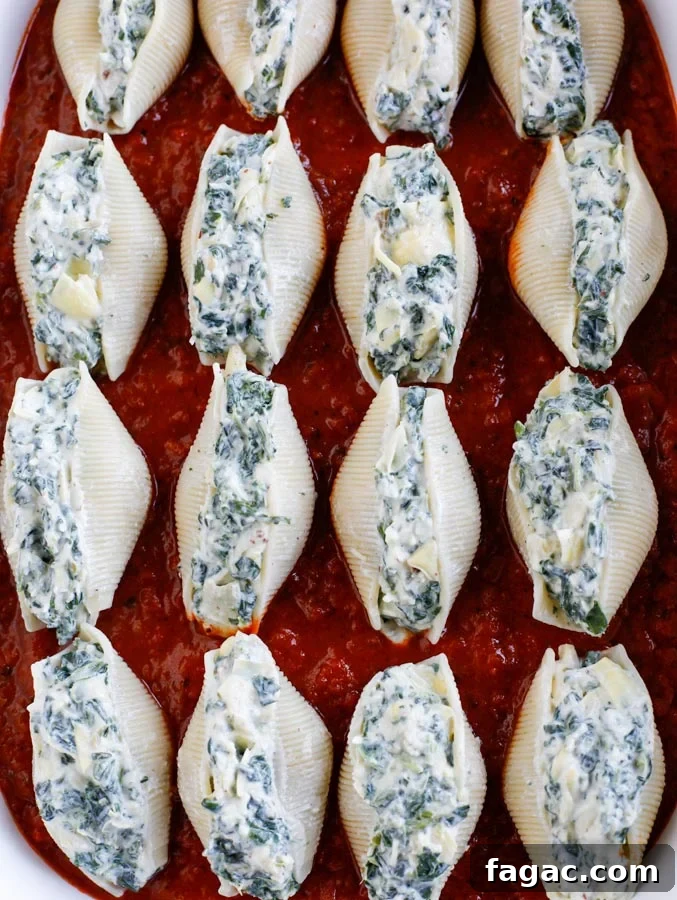 Spinach and Artichoke Stuffed Pasta Shells for Dinner 4 Spinach artichoke stuffed shells lined up in a baking dish.