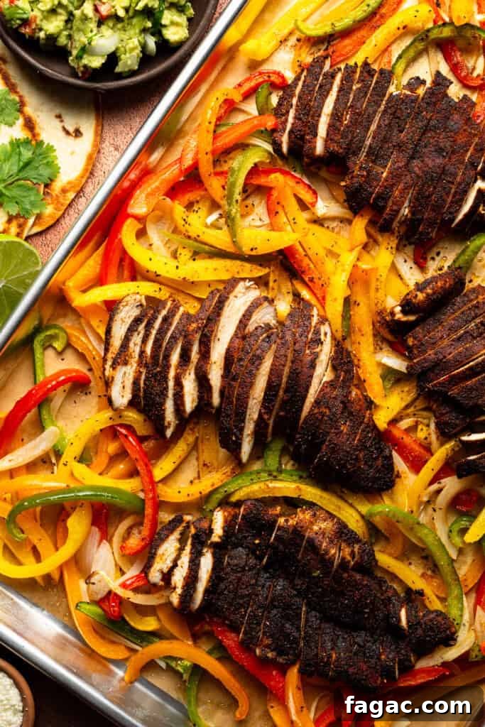 Weeknight Sheet Pan Chicken Fajitas Recipe for Quick Dinners 2 A sheet pan full of roasted bell peppers, onion slices, and seasoned sliced chicken breast.