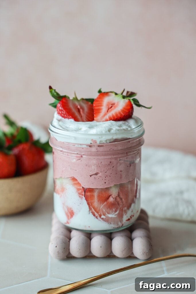 Light and Creamy Strawberry Mousse Without Gelatin 2 A jar of strawberry yogurt mousse with whipped cream.