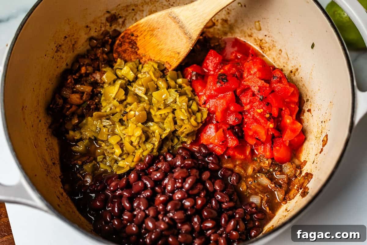 Quick Chicken Tortilla Soup Recipe for Cozy Weeknight Meals 11 fire roasted tomatoes, green chilies, and black beans in a pot with the onions and spices.