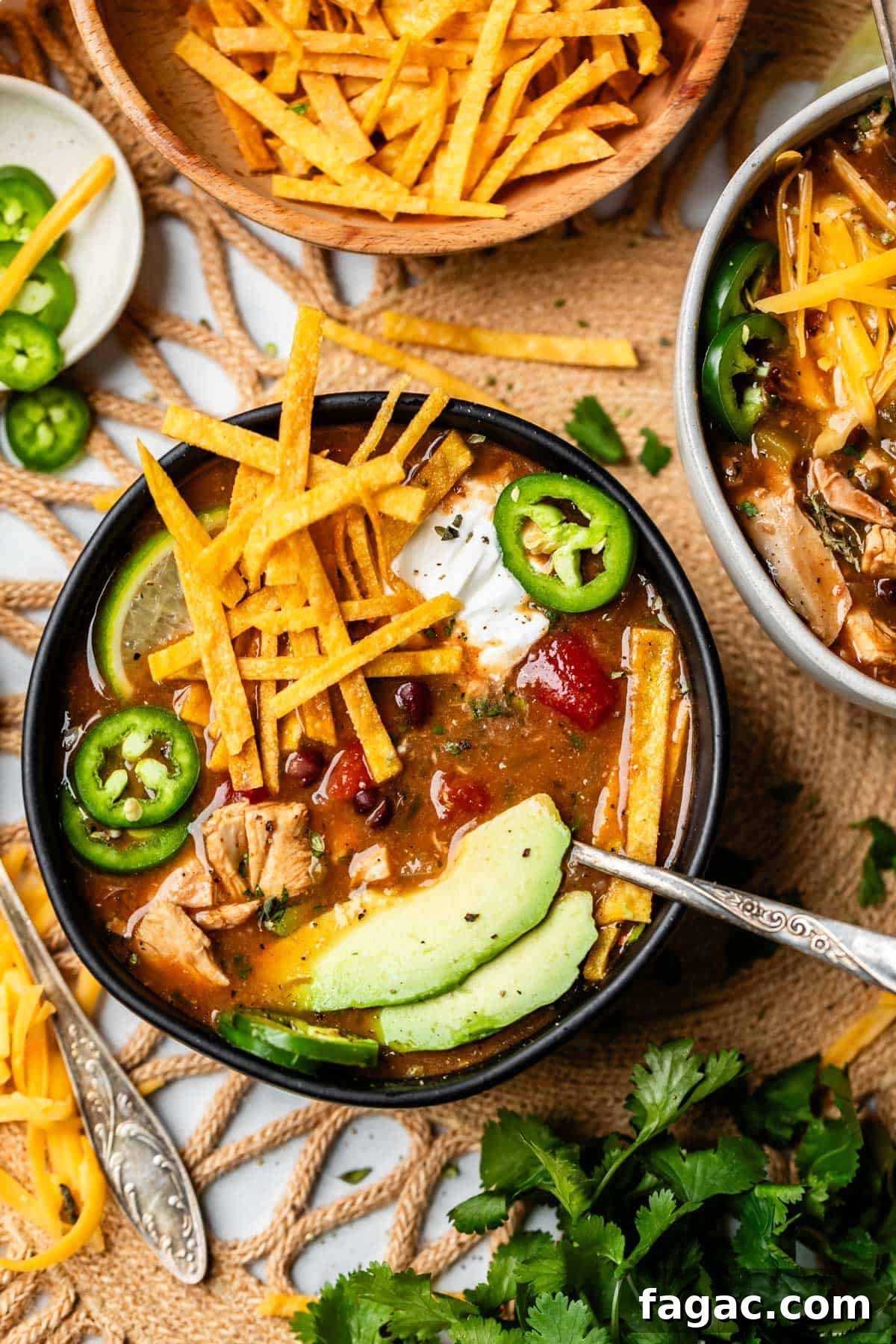 Quick Chicken Tortilla Soup Recipe for Cozy Weeknight Meals 5 table setting with a few bowls of chicken tortilla soup with toppings.