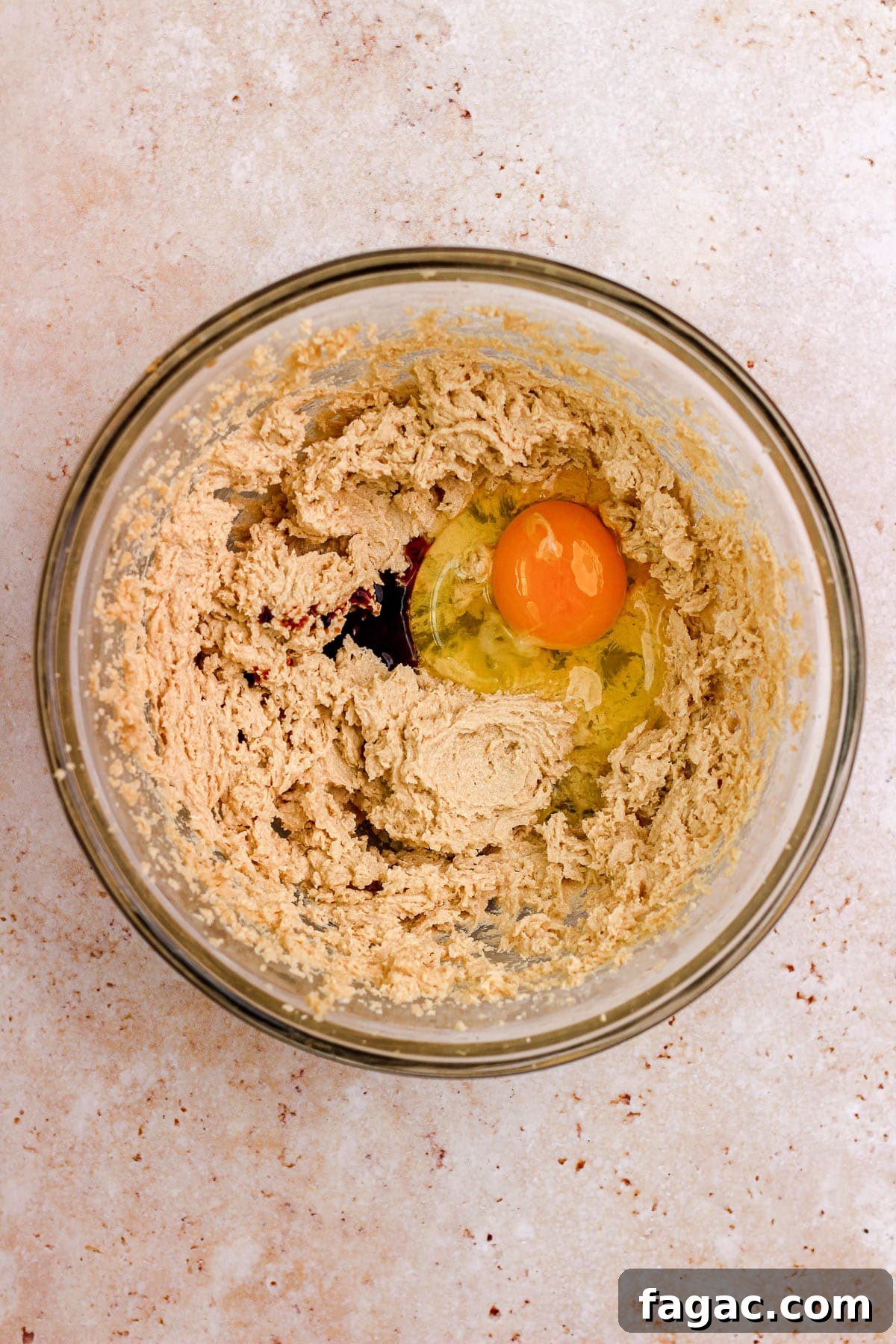 A glass bowl filled with sugar cookie dough and eggs.