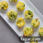 A tray of mini broccoli and cheddar egg bites on a gray table.