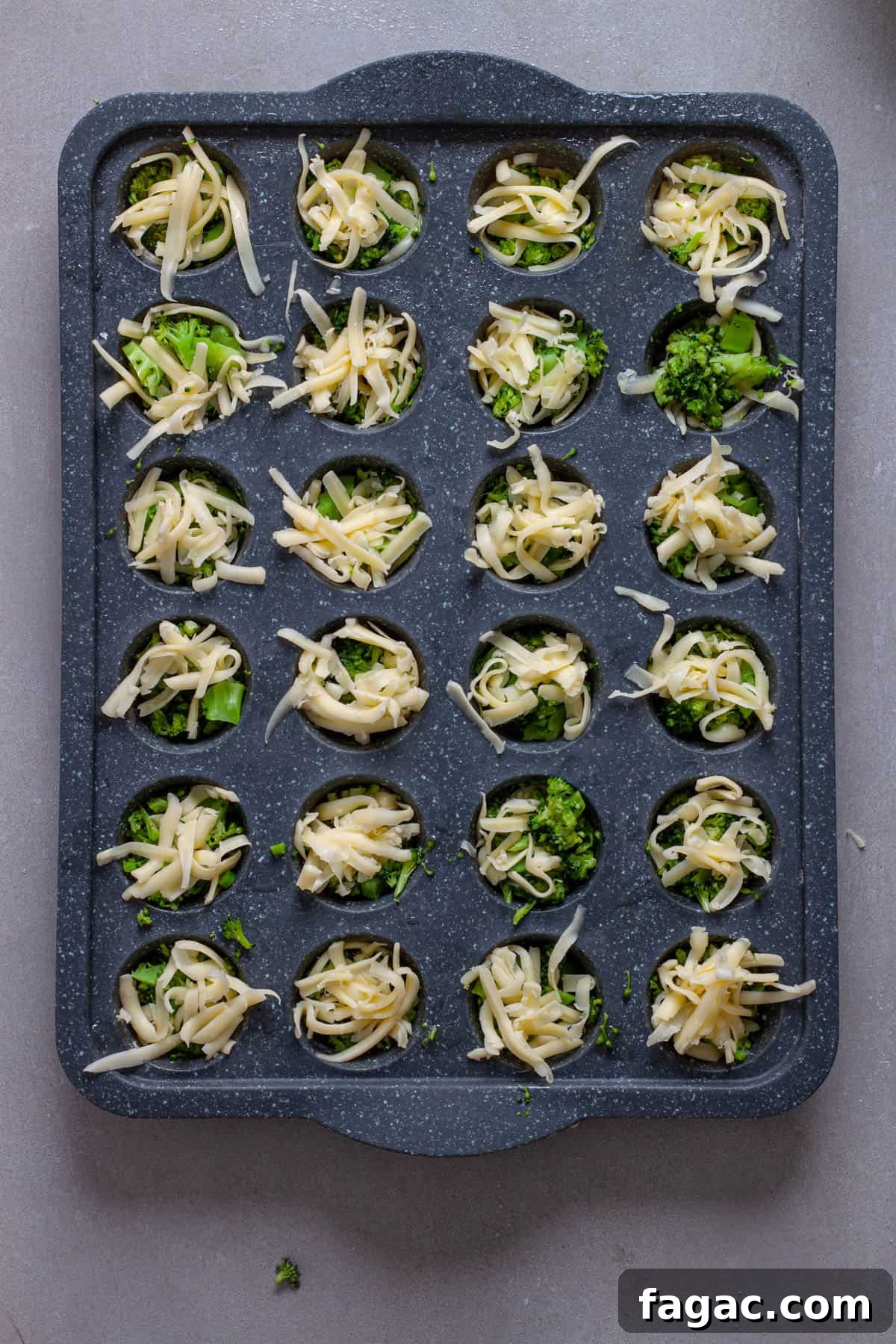 Broccoli Cheddar Mini Egg Bites: Protein-Packed Breakfast Bites 5 A mini muffin pan with shredded cheese and chopped broccoli.