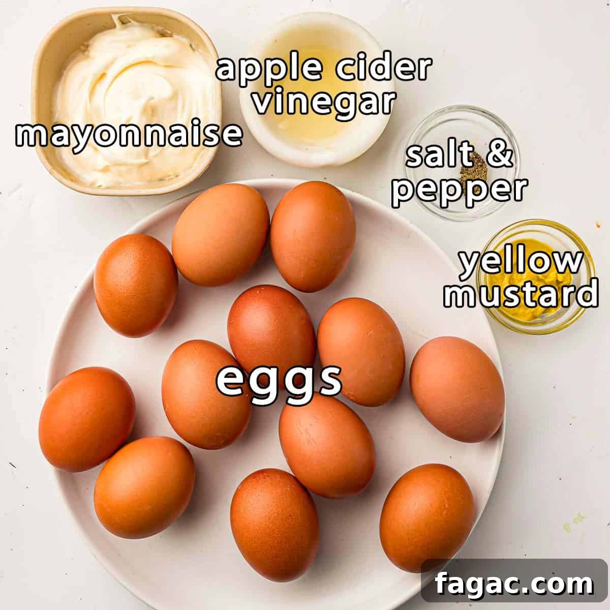 Overhead view of ingredients - eggs, mayonnaise, apple cider vinegar, yellow mustard, salt, and pepper.