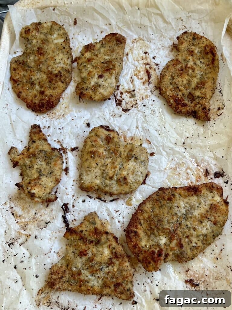Finished baked Italian chicken cutlets on sheet pan.