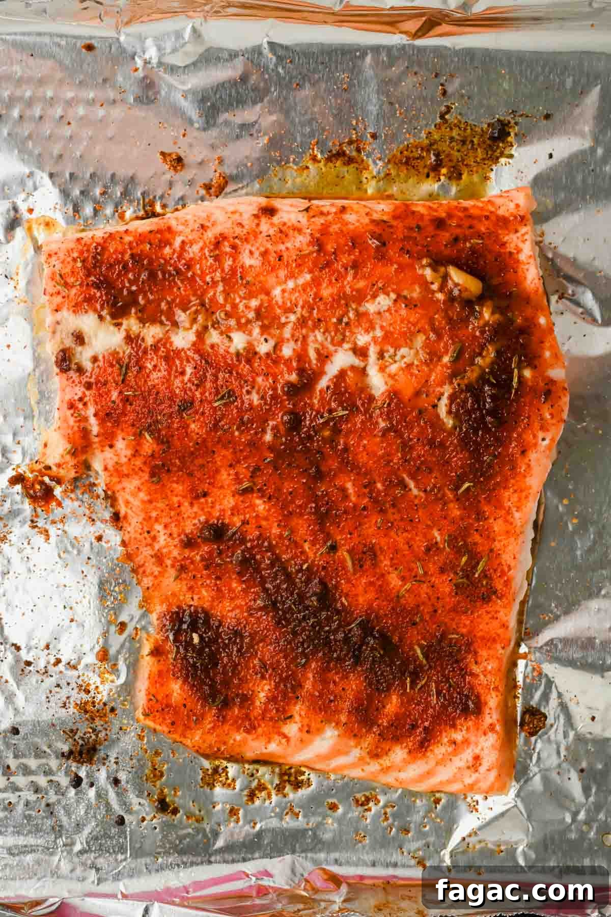 slice of seasoned baked salmon on tinfoil.