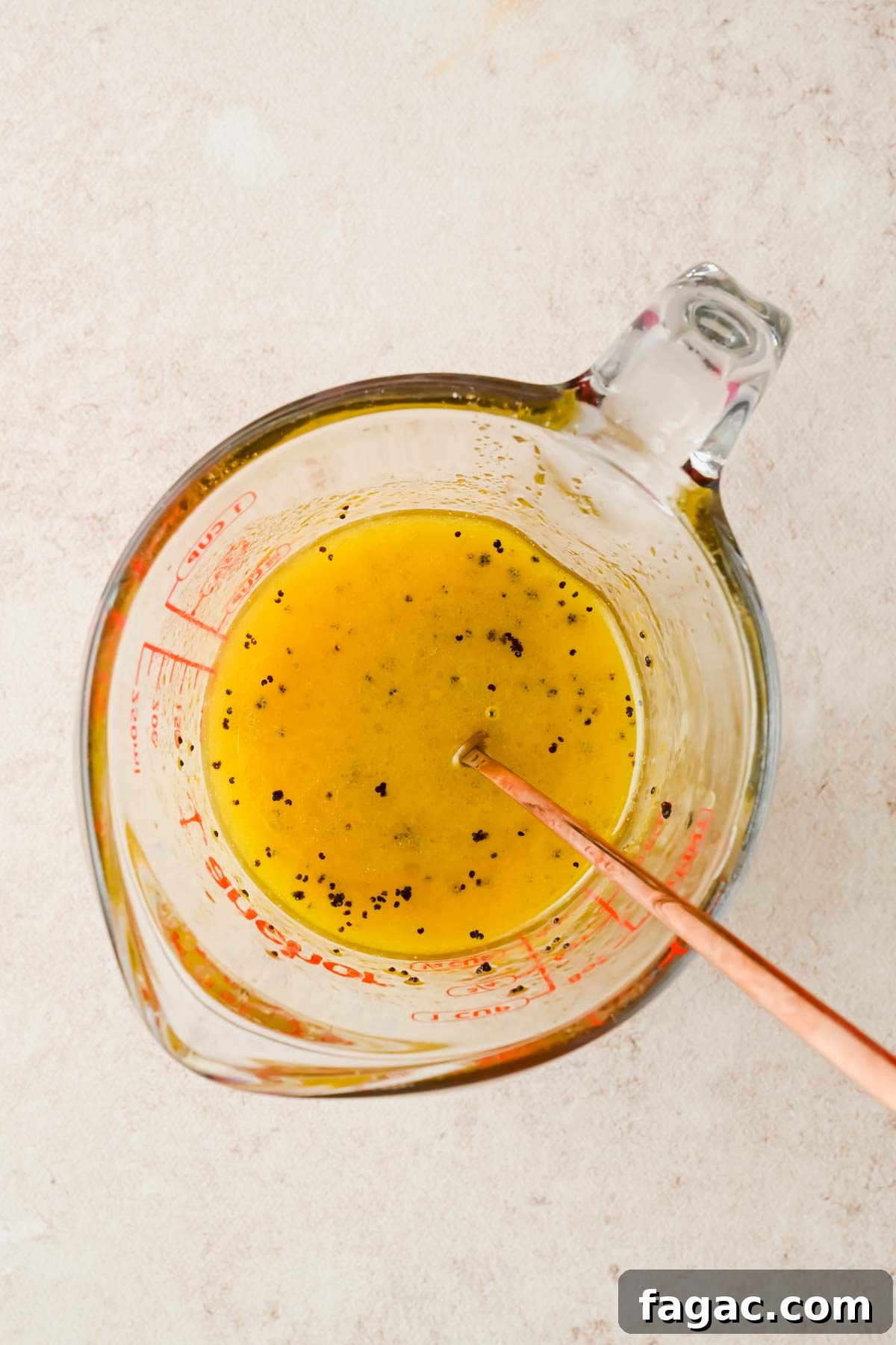 homemade salad dressing in glass measuring cup.