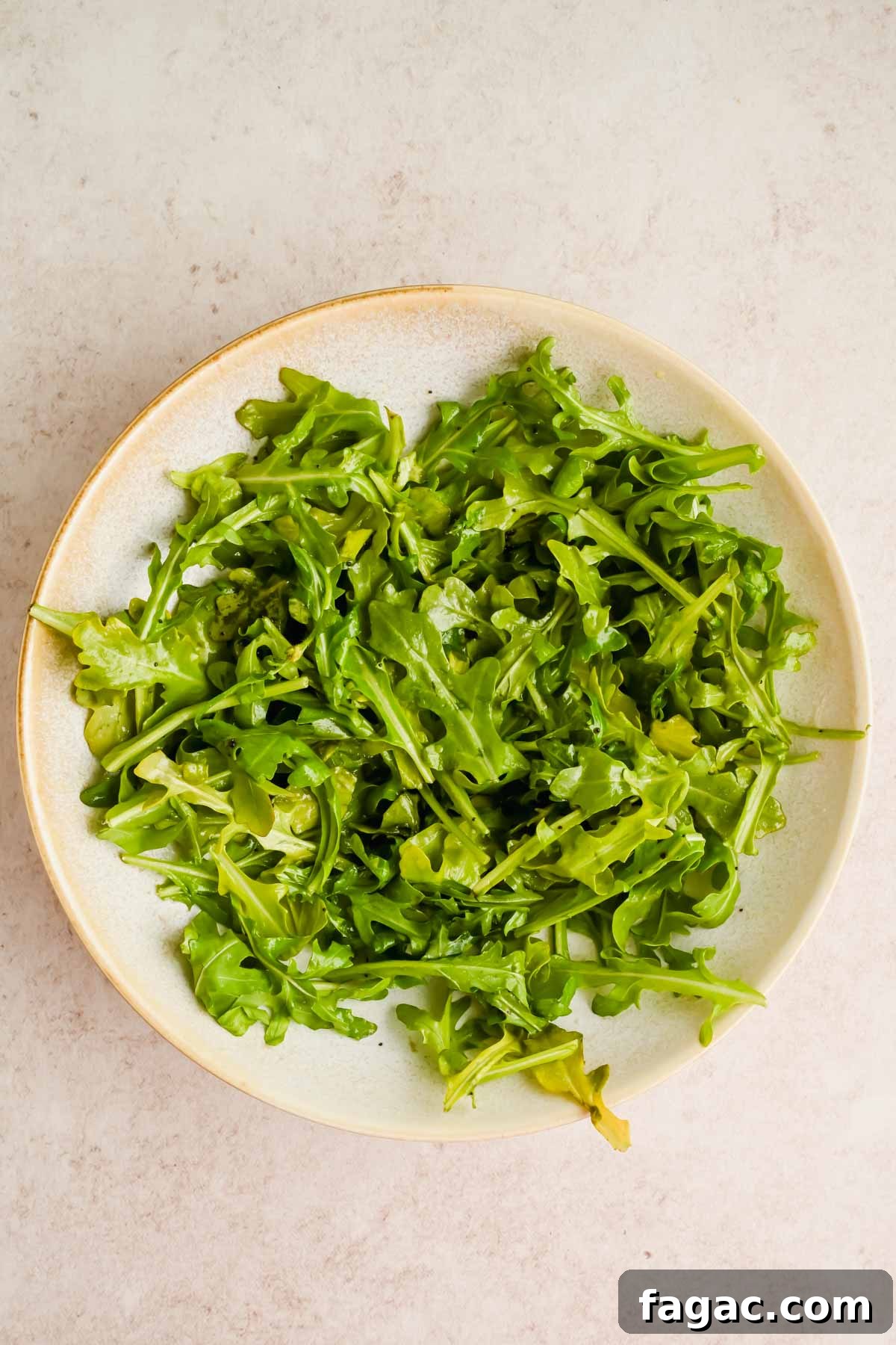 arugula in large serving bowl.