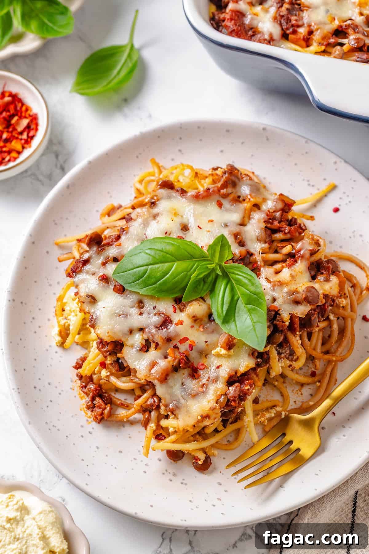 Plate of vegan million dollar spaghetti Plate of million dollar spaghetti with fork.