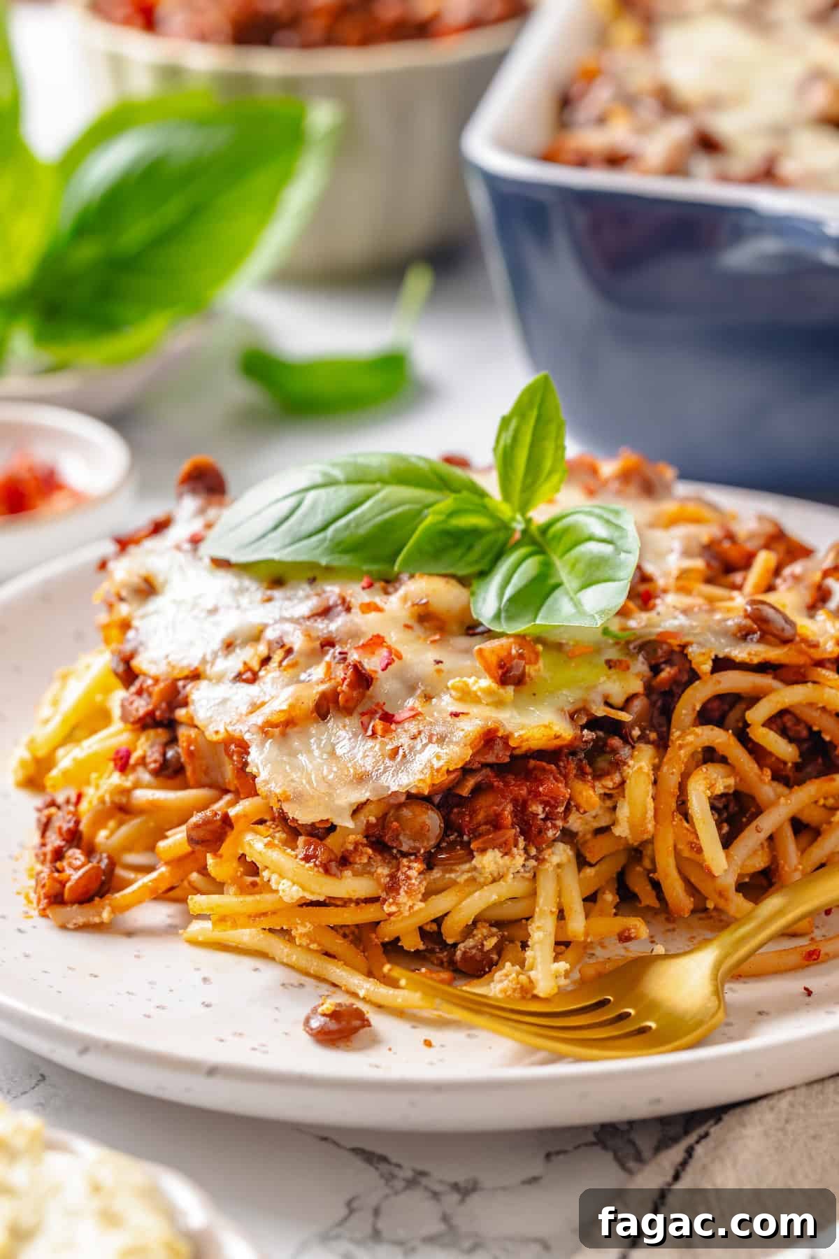 Served vegan million dollar spaghetti Portion of million dollar spaghetti on plate with fork.