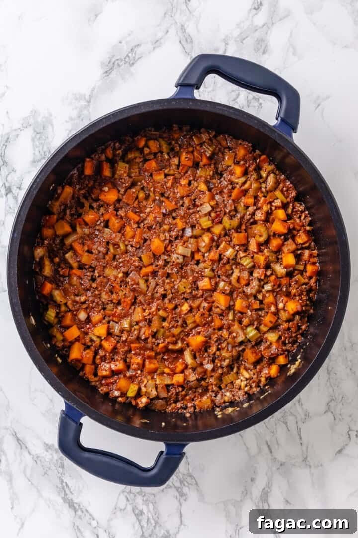 Pour in the wine. Vegan bolognese sauce in skillet.