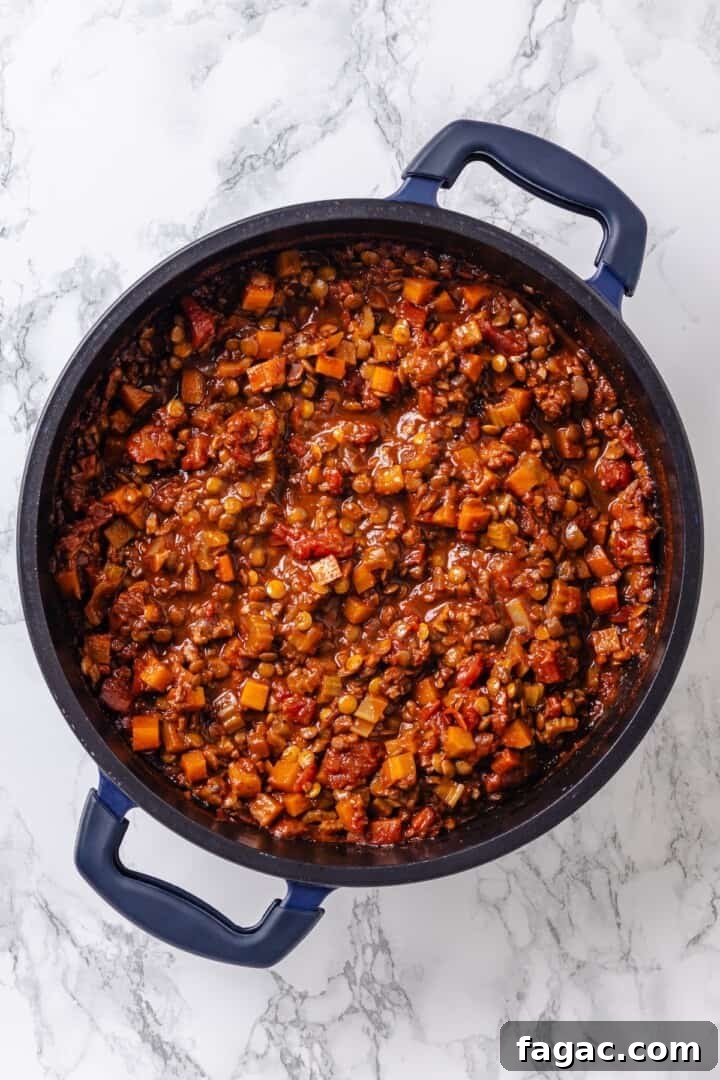 Add lentils, broth, tomatoes, and sugar. Vegan bolognese sauce in pan.