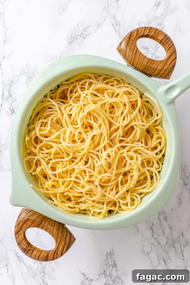 Cook the pasta. Spaghetti draining in colander.