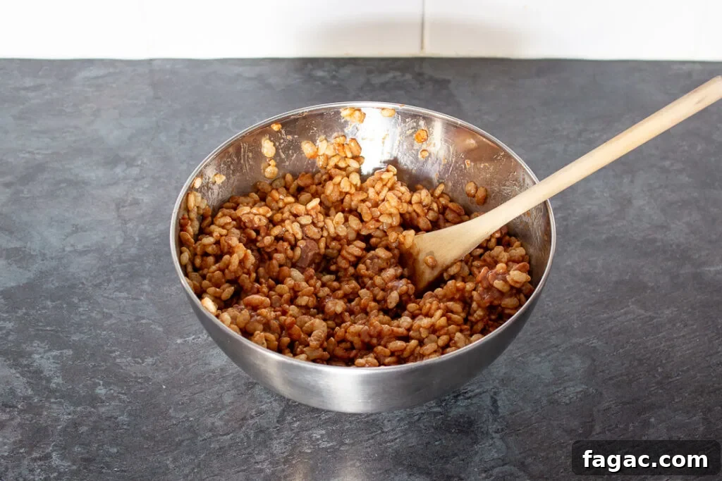 Quick Mars Bar Slice Recipe — No-Bake Chocolate Treat 6 Rice Krispies cereal mixed with melted mars bars in a large mixing bowl.