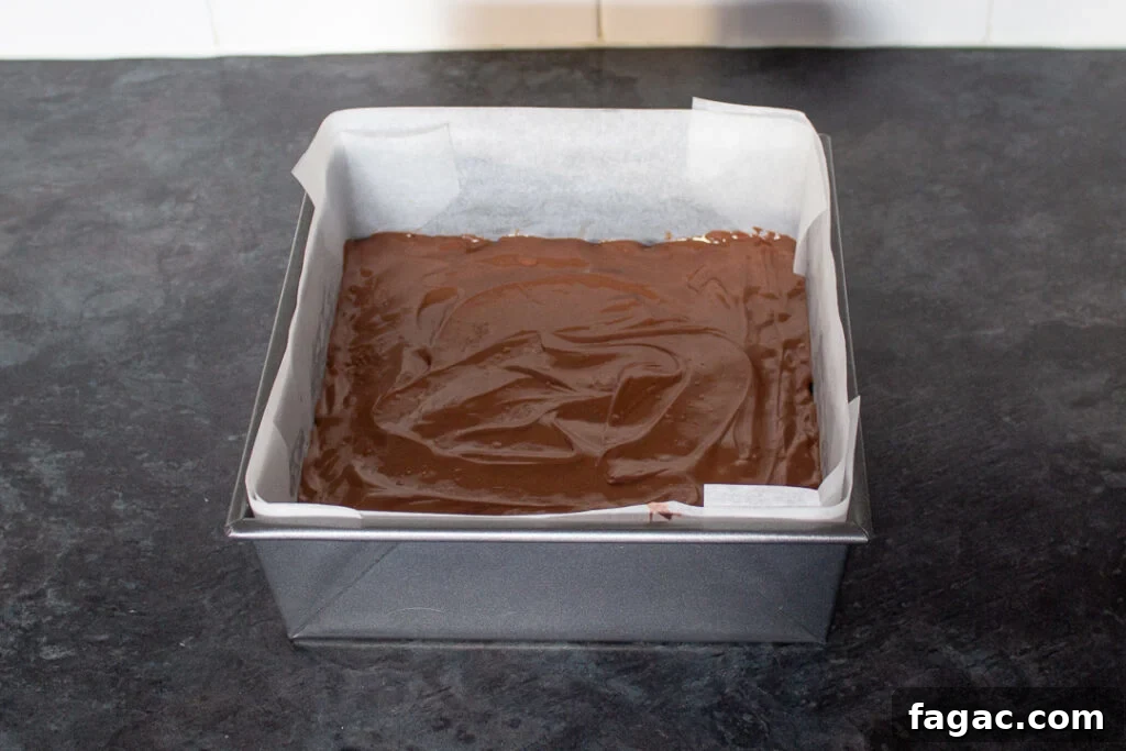 Quick Mars Bar Slice Recipe — No-Bake Chocolate Treat 9 Melted milk chocolate smoothed over the top of a melted Mars Bar and Rice Krispie mixture in a square baking tin.