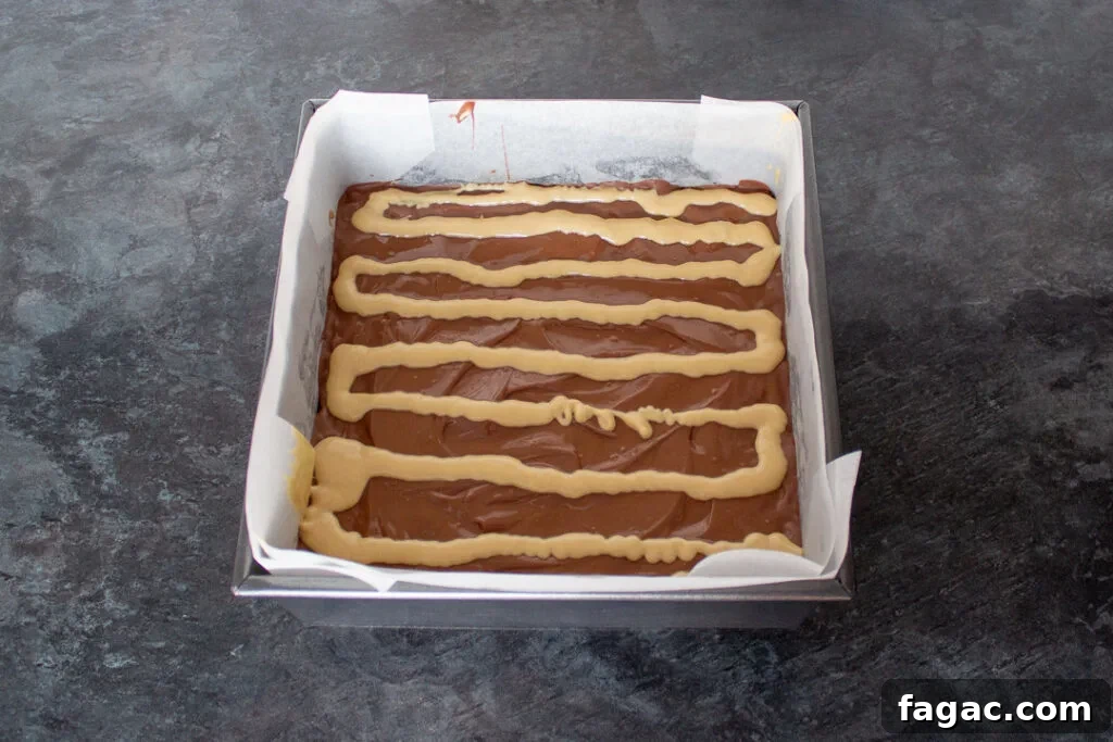 Quick Mars Bar Slice Recipe — No-Bake Chocolate Treat 11 Melted blonde chocolate piped in lines on top of the milk chocolate topping.