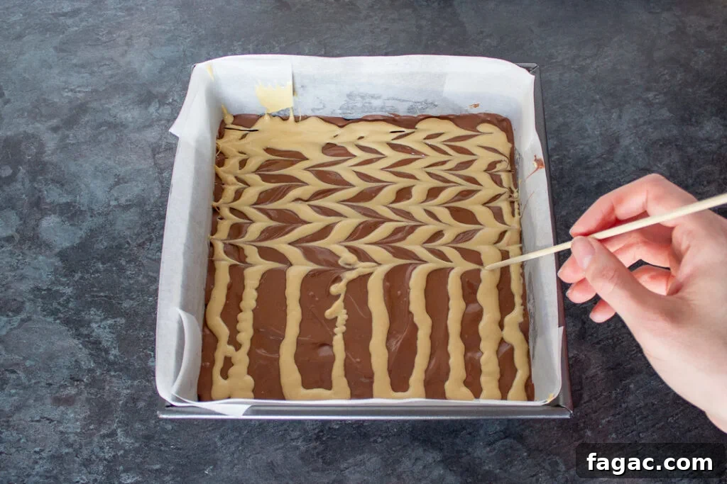 Quick Mars Bar Slice Recipe — No-Bake Chocolate Treat 12 Melted blonde chocolate being feathered on top of the melted milk chocolate.