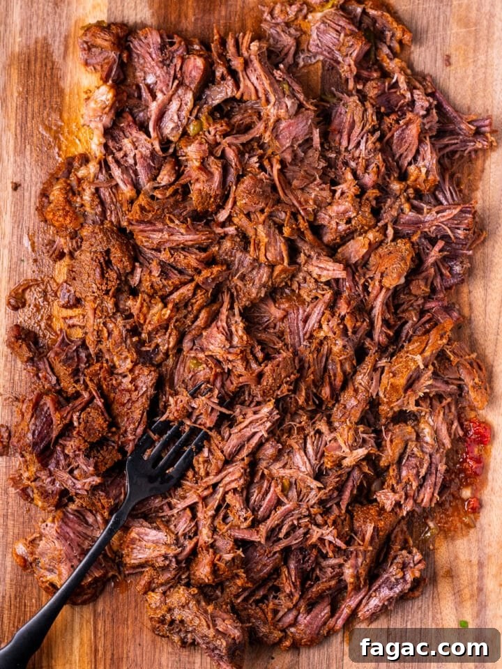 shredded Mexican beef on a cutting board