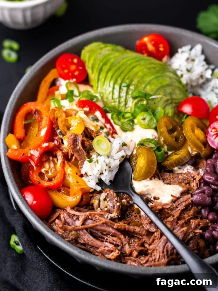 bite of shredded beef and rice on a fork in a beef burrito bowl