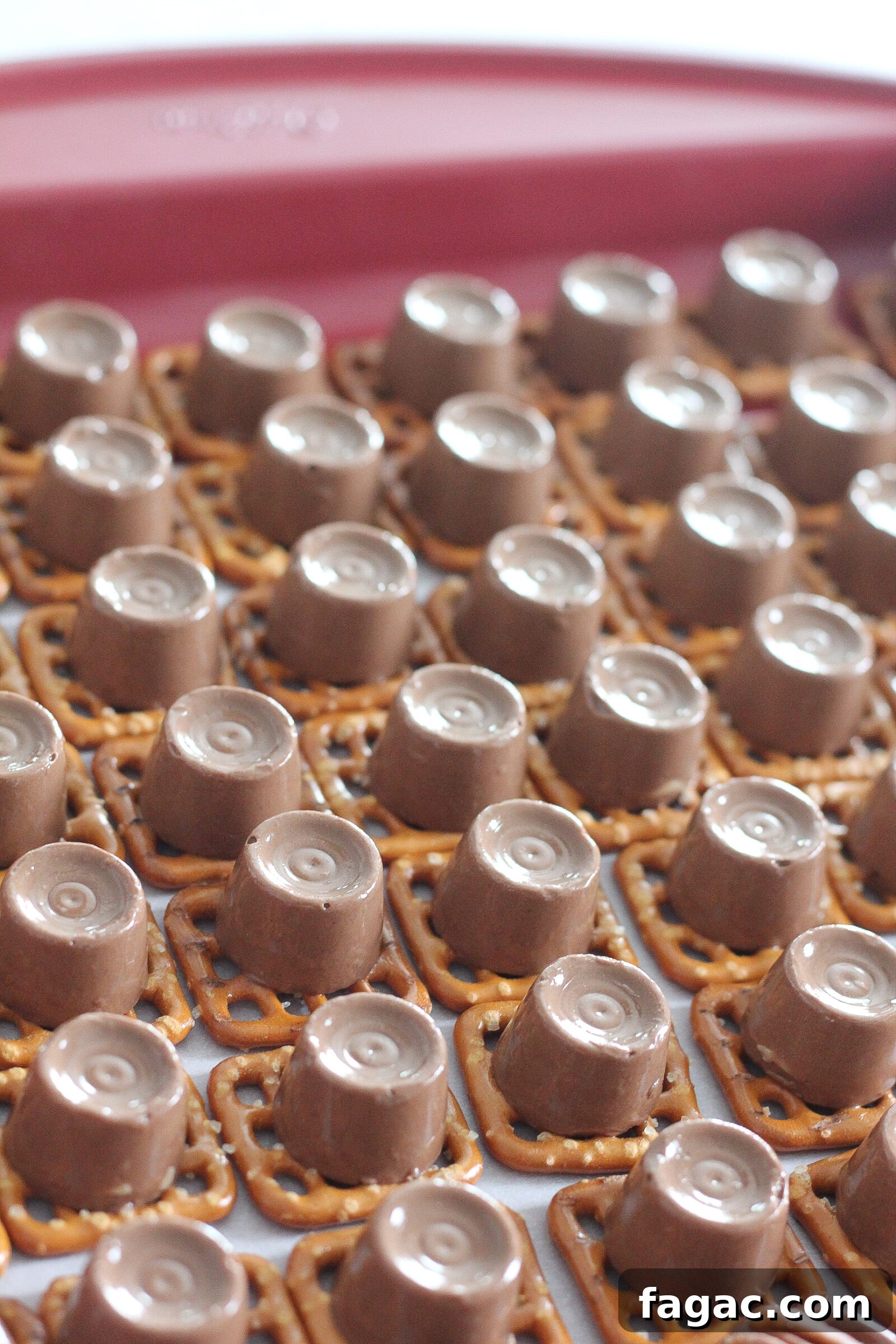 Pecan being pressed onto melted Rolo