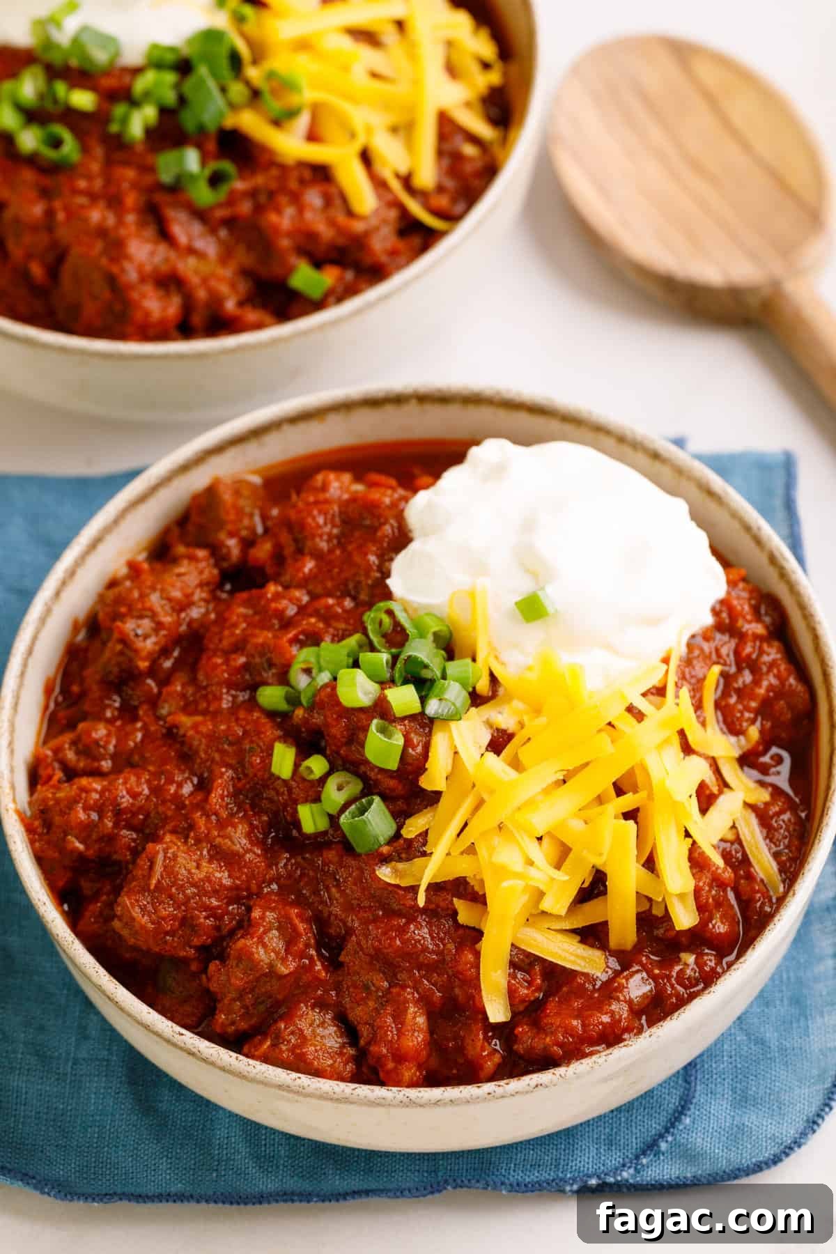 Authentic Texas Chili Recipe: Classic Beef and Spice Guide 2 bowl of texas chili topped with chopped green onions, sour cream and shredded cheddar cheese
