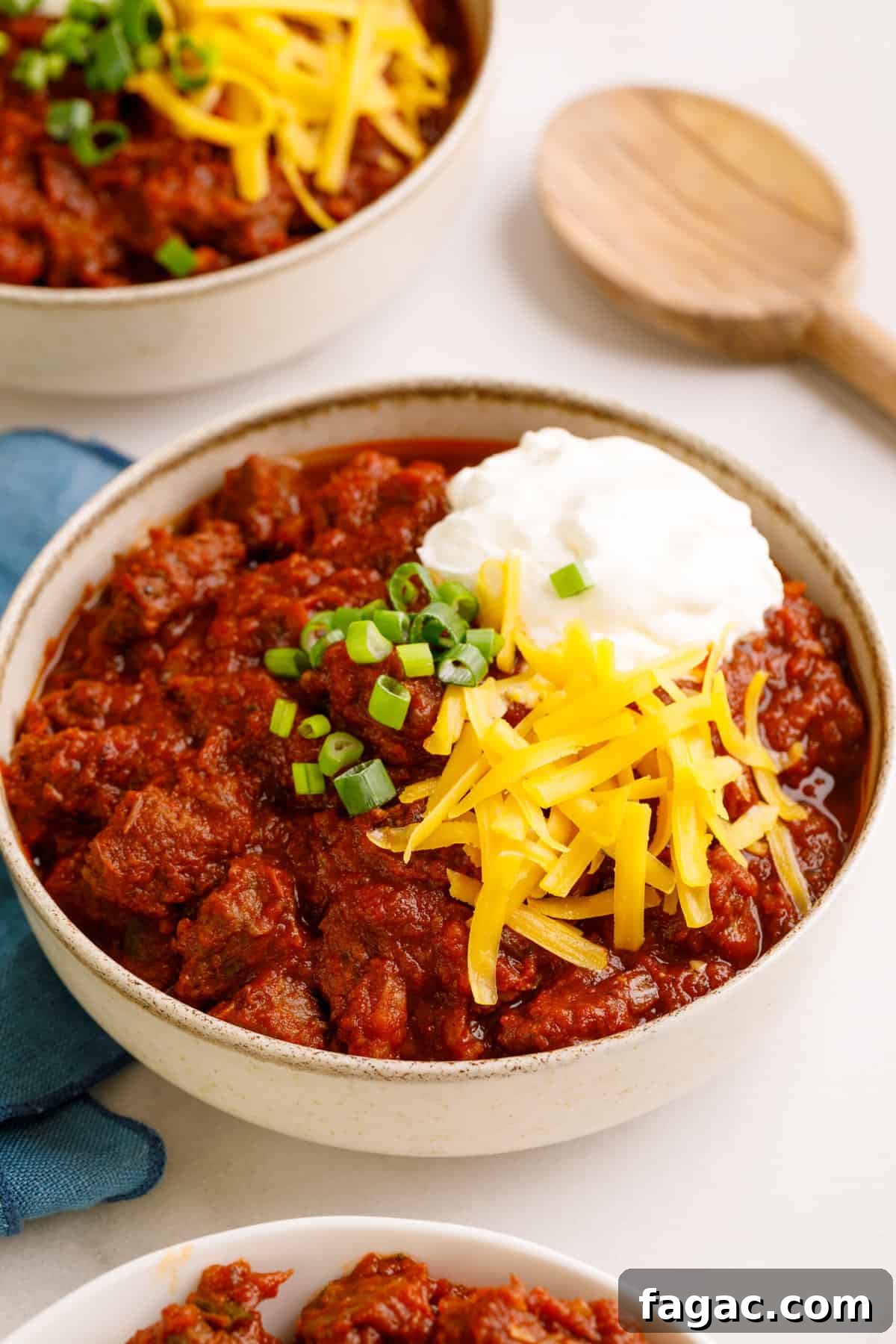 Authentic Texas Chili Recipe: Classic Beef and Spice Guide 13 bowl of texas chili topped with chopped green onions, sour cream and shredded cheddar cheese