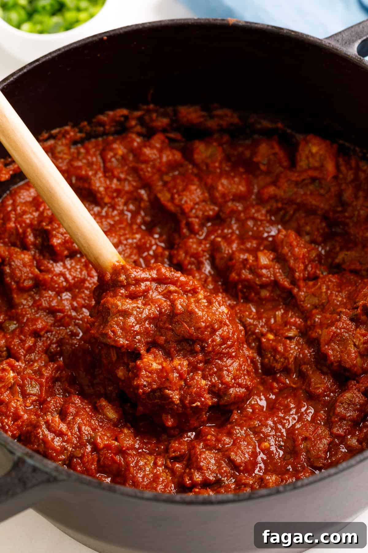 Authentic Texas Chili Recipe: Classic Beef and Spice Guide 3 large pot of texas chili and a wooden spoon digging in