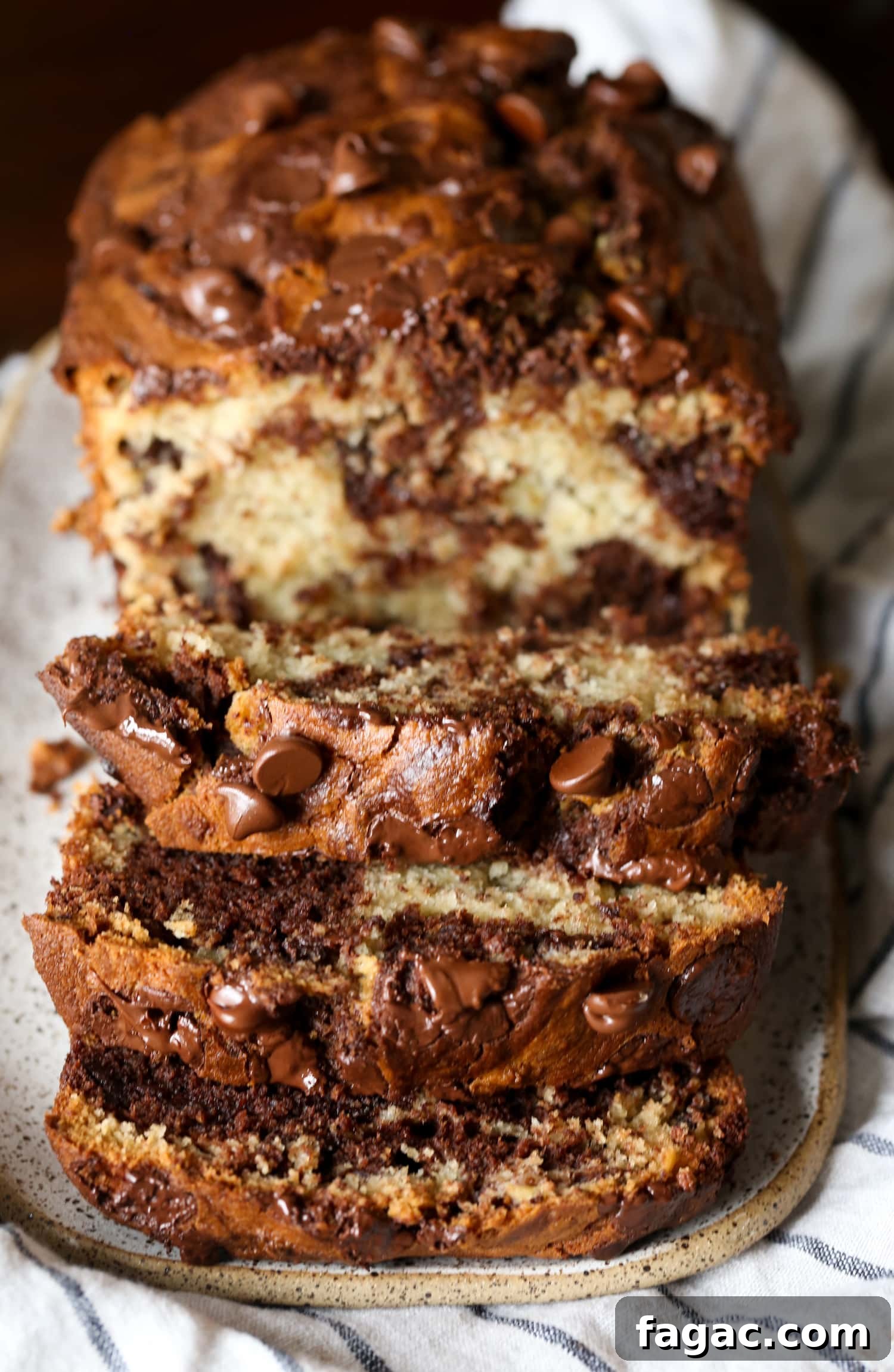 Chocolate Marble Banana Bread Recipe 2 A loaf of chocolate marbled banana bread sliced to reveal the marbled interior.
