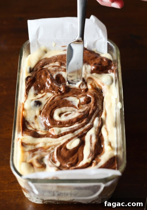 Chocolate Marble Banana Bread Recipe 7 A knife is used to gently swirl the chocolate and regular banana bread batters together in a loaf pan.